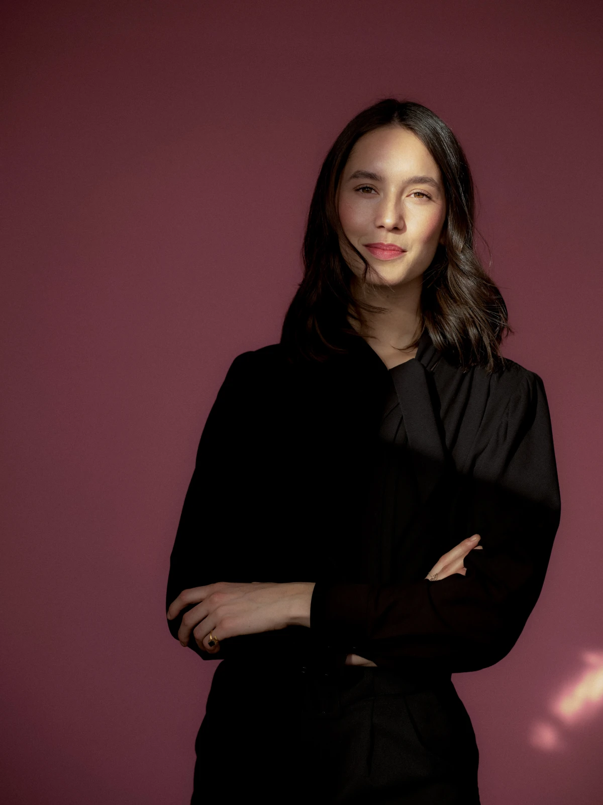 Studio portrait of woman in black blazer against burgundy background for Finstral campaign