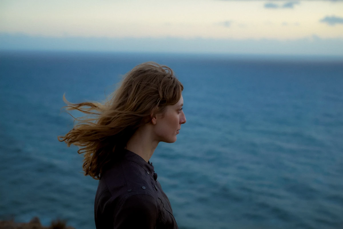 Woman in profile by the sea in coastal wind for BMW cinematic lifestyle campaign. Model: Tatiana Chechetova