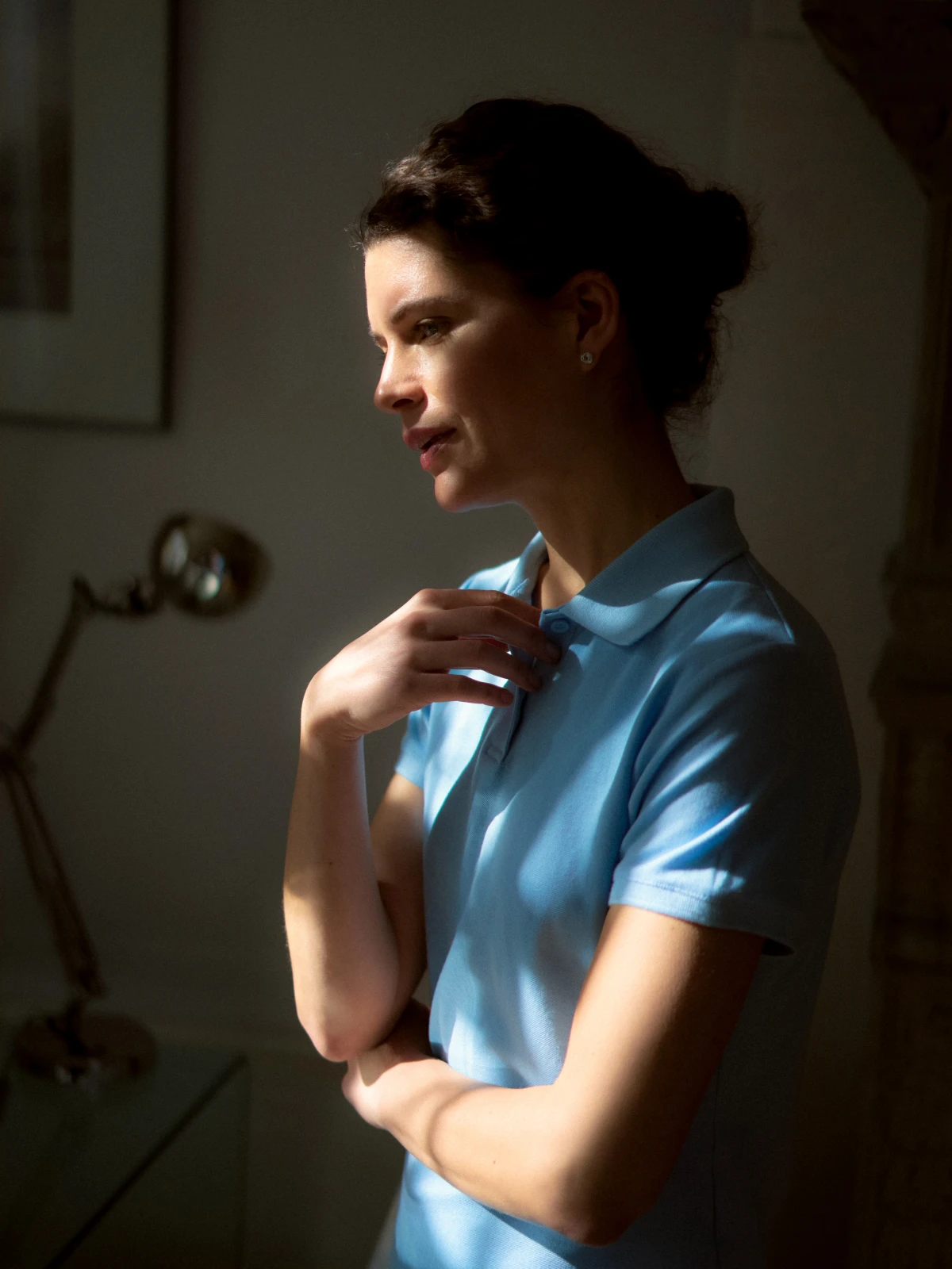 Woman in blue polo shirt in soft interior light for Ratiopharm Pharma and lifestyle campaign