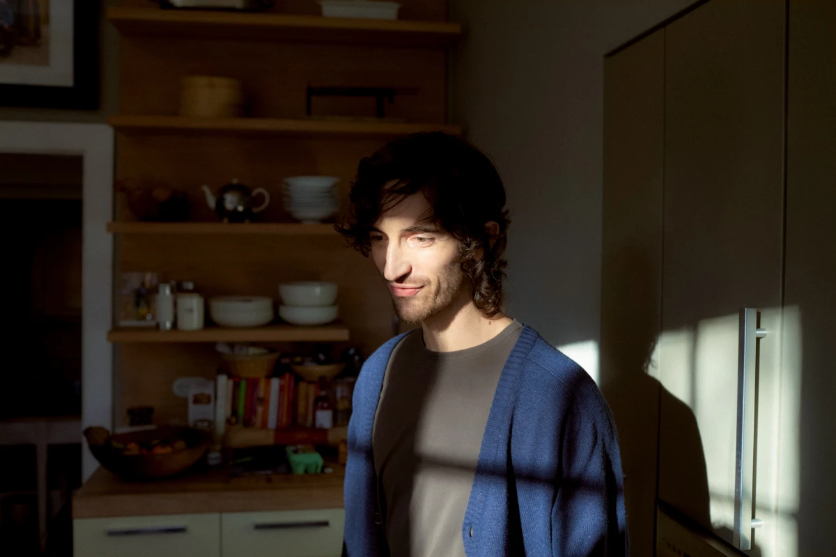 Man in cardigan standing in domestic interior with morning light for HSBC lifestyle banking campaign