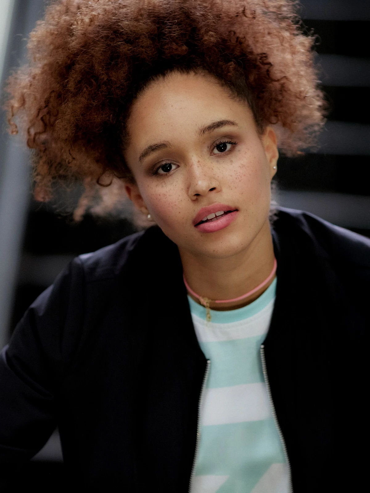 Close portrait of young woman in striped top and dark jacket for Adidas commercial lifestyle campaign