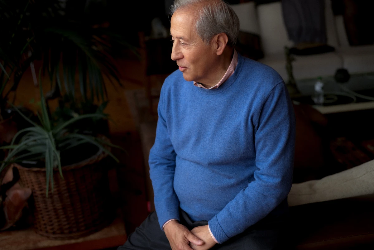 Older man standing at home in blue sweater for ERGO insurance lifestyle portrait